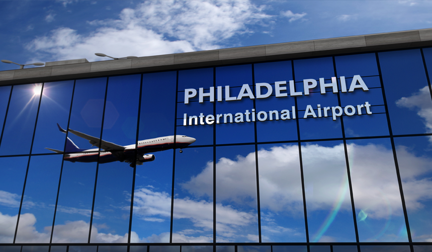 A photo of the Philadelphia Airport with a a airplane's image reflected across windows of the airport.